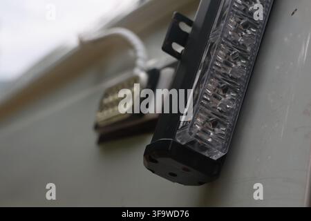 A clear led light bar mounted on vehicle panel, showing textured lens and black metal housing in close up automotive lighting detail with shallow focu Stock Photo