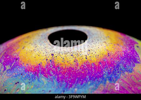 Multicolored abstract chaotic pattern inside of the soap bubble, closeup. Stock Photo