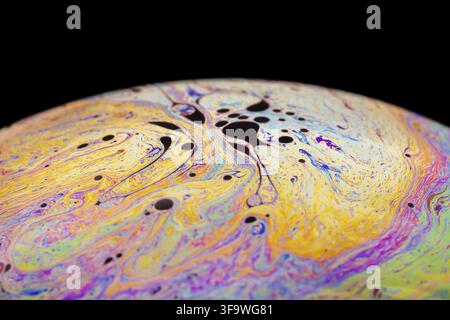 Multicolored abstract chaotic pattern inside of the soap bubble, closeup. Stock Photo