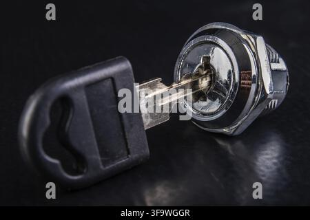 Small lock for the metal cabinet and keys. Accessories for securing private property. Dark background Stock Photo