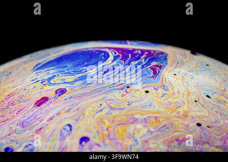 Multicolored abstract chaotic pattern inside of the soap bubble, closeup. Stock Photo