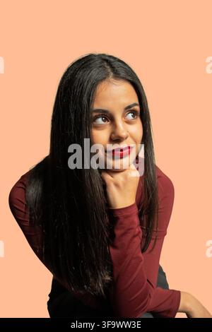 Young woman posing in studio, contemplating, and looking away with copy space Stock Photo