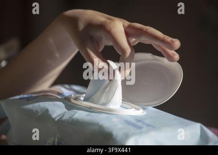 Hand picked a wet wipes from package box, Wet wipes in a children's hand Stock Photo