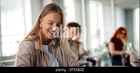 Female student writing notes during university lecture. Stock Photo