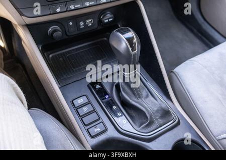 High angle view of an automatic gear shift lever and electronic parking brake buttons on the central console of a modern car. Stock Photo