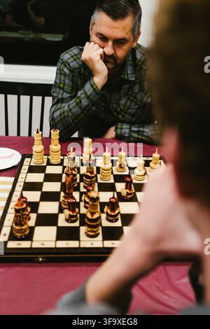 Man contemplates his next move in chess game Stock Photo