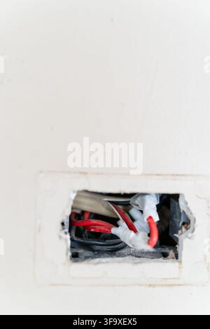 Dangerous exposed wiring in a wall outlet Stock Photo