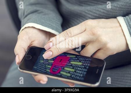 Mobile phone in female hands with screen showing compromised virus infected device. Cyber attack. Data breach concept Stock Photo
