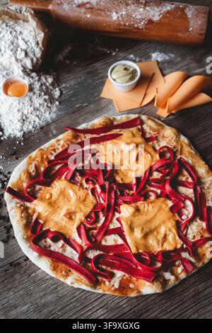 Unusual homemade pizza with beet pasta and cheese on a wood table Stock Photo