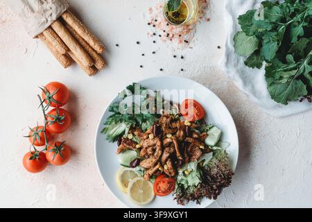 Fresh grilled chicken salad with tomatoes and breadsticks Stock Photo