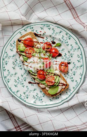 Avocado toast with poached egg and tomatoes Stock Photo