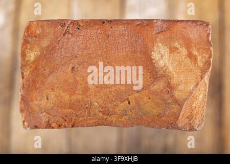 Red brick on a wooden table. Building material from baked clay. Light background Stock Photo