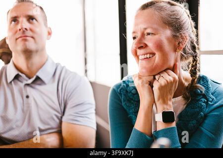 Smiling mature woman listens during a meeting Stock Photo