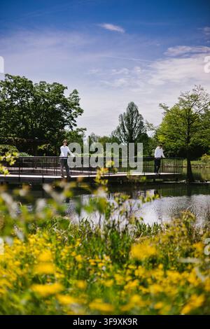 Two men relax on a footbridge on a sunny day Stock Photo