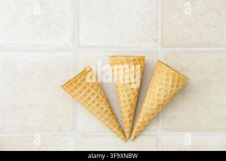 Three empty ice cream waffle cones on a white background, top view Stock Photo