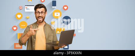 Happy Young Man Holding Laptop And Pointing At Screen, Business Concept, Office Setting Stock Photo