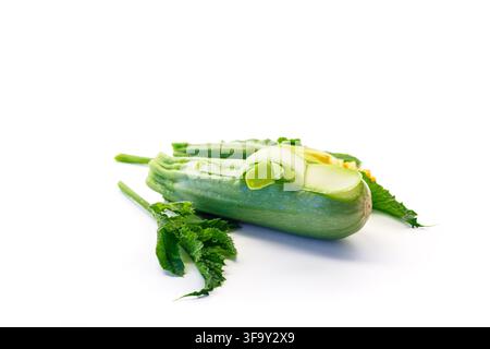 Fresh zucchini with peeled ribbons and leaves isolated on white background . Stock Photo