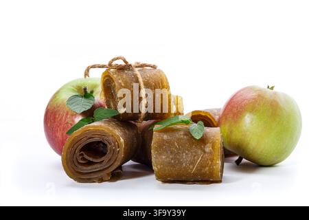 Sweet homemade apple leather rolls and ripe fruit isolated on white background . Stock Photo