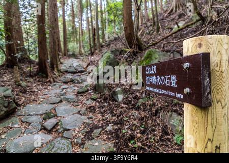 A sign on the Sukumogawa Nature Trail near Hakone, Kanagawa Prefecture, Japan, announces the start of a stone-paved section of the historic Tōkaidō road dating from the Edo period. The shogunate had this eastern pass section between Yumoto and Hatajuku reinforced in 1680 to keep it from turning into a muddy track in the wet mountain climate. Stock Photo