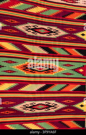 Colorful traditional woven carpet with repeating geometric ornaments and bright stripes Stock Photo