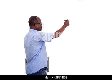 teacher in glasses writing on the board with a marker in a classroom. Stock Photo