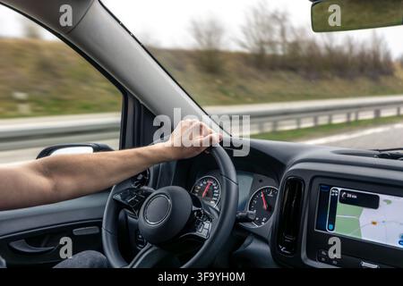 Driver Hand On Steering Wheel With Navigation Screen Stock Photo