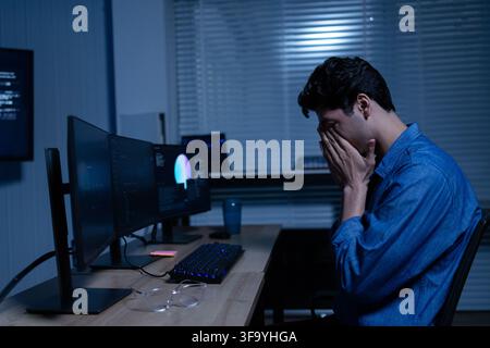 Tired Young Professional Working Late At Computer Stock Photo