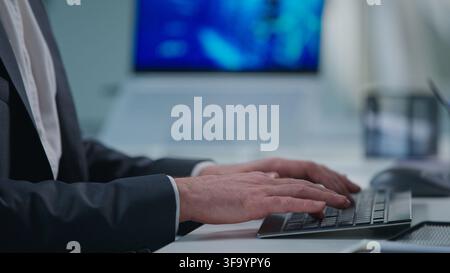 Close up male hands typing computer keyboard Caucasian unknown business man working online chatting indoors at office table. Unrecognizable Stock Photo