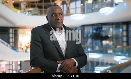 Serious middle-aged African American business man thinking dreaming pondering work solution mature businessman male worker think dream ponder dreamy Stock Photo