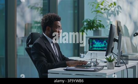 Concentrated busy African American business man typing computer working with corporate software in office. Ethnic businessman male employer Stock Photo