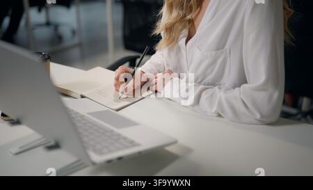 Caucasian business woman office CEO in headset talking conference video call laptop chat making notes writing female businesswoman talk professional Stock Photo
