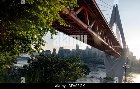 Chongqing, China - 9 Jun 2026 - a dramatic low angle of the iconic Qiansimen Bridge cuts a powerful diagonal across the frame, showcasing its striking Stock Photo