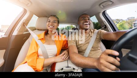 Happy young Black couple smiling while traveling together in car Stock Photo