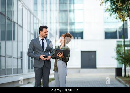 Business colleagues discussing project ideas outdoors Stock Photo