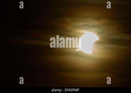 Solar eclipse over the landscape, showing dark lunar silhouette gliding across the solar disk Stock Photo