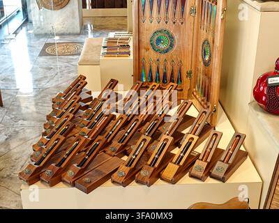 Wooden pens arranged on display. Decorative wooden box with colorful patterns in background Stock Photo