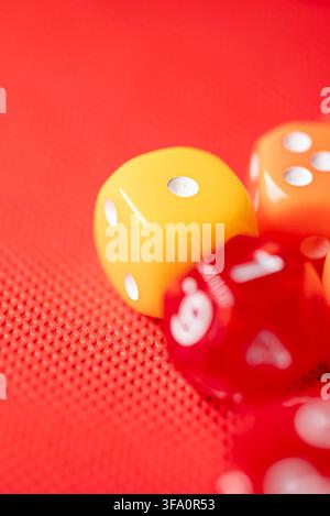 Bright yellow die on red mesh background with blurry red dice The Concept of decision making and game probability Stock Photo