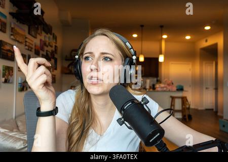 Podcaster in a home studio with headphones Stock Photo
