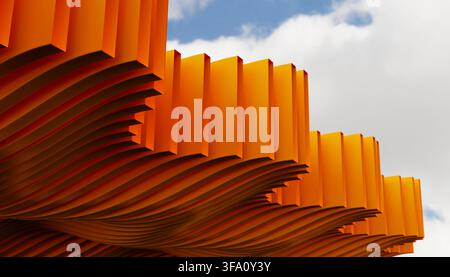 Abstract 3D render of layered yellow ripple panels forming a flowing geometric structure against a soft cloudy sky, with dramatic perspective, shadows Stock Photo