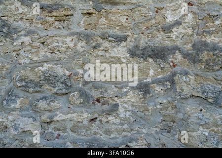 Close up view of ancient fortress fortification structure build from raw natural stones. Background texture of weathered grey castle masonry with conc Stock Photo