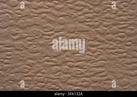 Close-up brown paper texture with an uneven embossed surface, creating a warm rustic abstract background for wallpaper, packaging, stationery, or natu Stock Photo