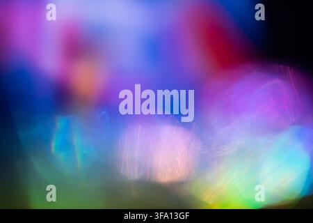 Vibrant abstract background of blurred bokeh lights in blue, purple, pink, green, and cyan tones, creating a dreamy luminous atmosphere with soft defo Stock Photo