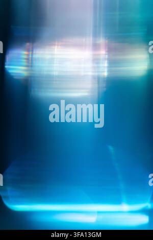 Abstract blue and cyan light streaks create a futuristic motion blur effect, with glowing horizontal reflections and soft vertical lines on a dark tec Stock Photo