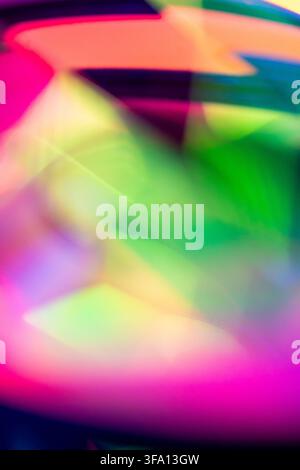 Vibrant abstract background with neon pink, green, yellow and blue light trails creating soft motion blur, layered shapes and luminous energy for mode Stock Photo