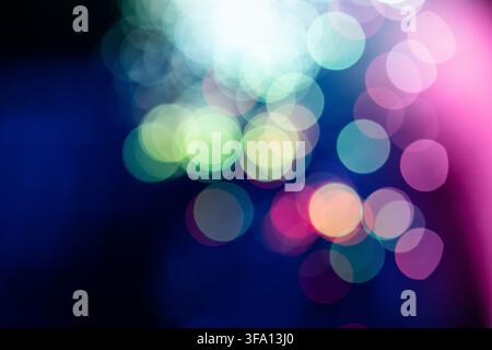 Abstract background of colorful out-of-focus lights in blue, pink, green, and purple tones, creating a dreamy bokeh effect with soft blur and luminous Stock Photo
