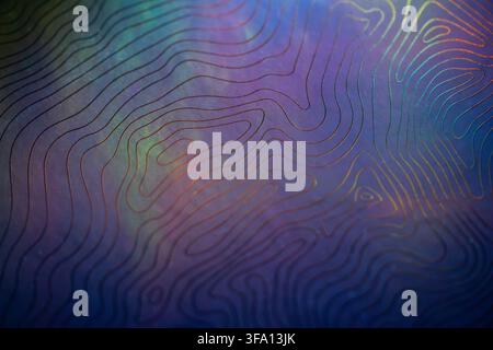 Abstract close-up of layered topographic contour lines over a dark iridescent surface, blending blue, purple, green, and orange tones into a modern te Stock Photo