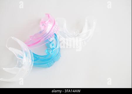Multicolored plastic orthodontic plates and mouth guards for children on a white background. High quality photo Stock Photo