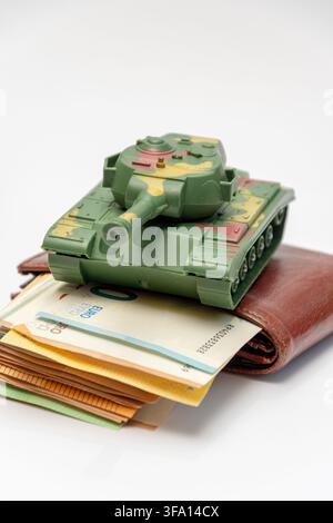 Green toy tank on a leather wallet with euro banknotes on white. Stock Photo