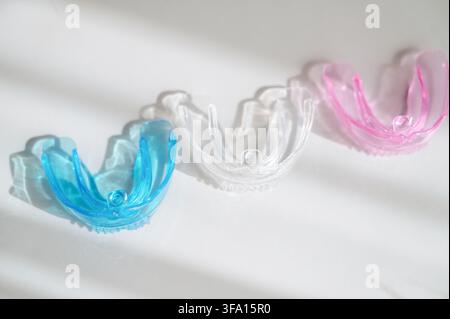 Multicolored plastic orthodontic plates and mouth guards for children on a white background. High quality photo Stock Photo