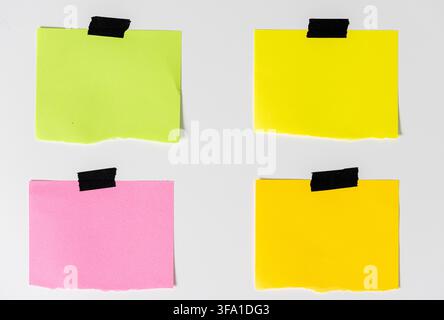 four blank colorful sticky note papers with black adhesive tape isolated on white background. template mockup Stock Photo